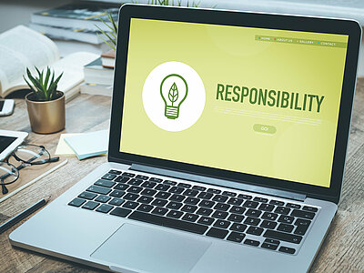Ein Laptop auf einem Schreibtisch mit dem Text "Responsibility" auf dem Bildschrirm
